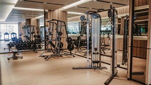 A gym with various exercise equipment, wooden floors, and large windows. - Ibis Samarinda (Samarinda)