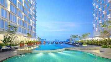 Una piscina al aire libre, tumbonas