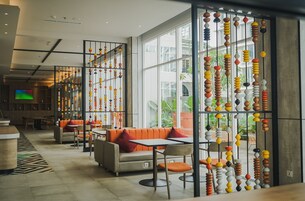 A modern interior with a seating area, a large window, and a decorative wall with hanging beads.