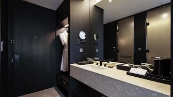 A modern bathroom with a dark wood vanity, a large mirror, and a dual sink.