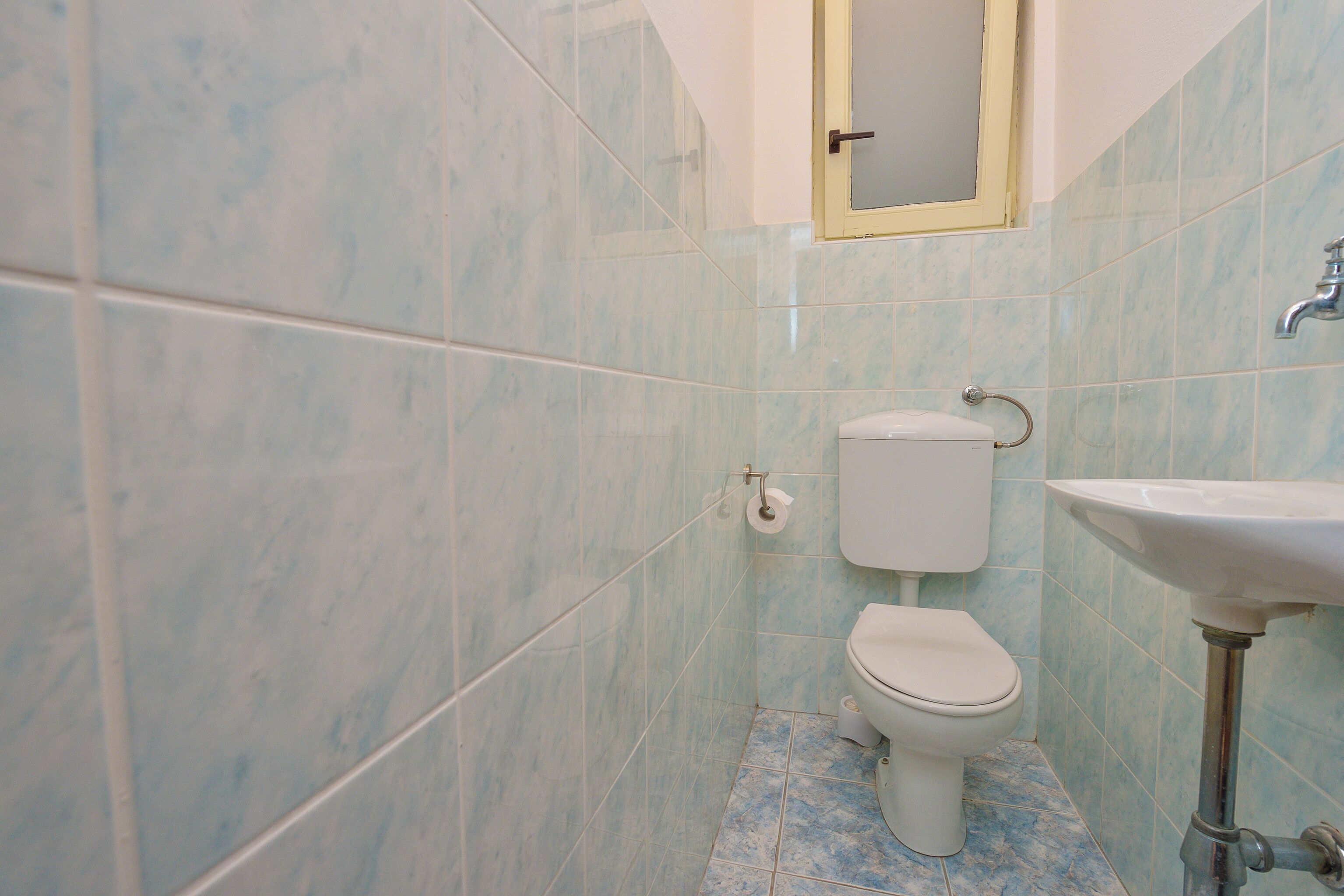 Ein Badezimmer mit Toilette, Waschbecken und Spiegel.