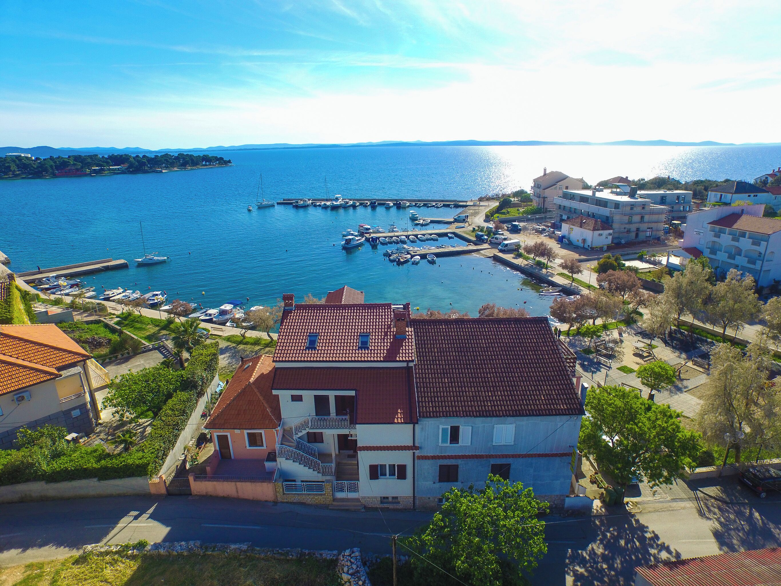 A coastal town with a marina, residential buildings, and a clear view of the sea.