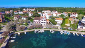 An aerial view of a coastal town with residential buildings, a marina with boats, and clear blue skies. - Beautiful sea View Apartment (Zadar)