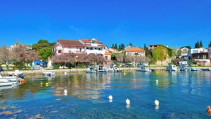A marina with boats docked, clear water, and houses along the shore. - Beautiful sea View Apartment (Zadar)