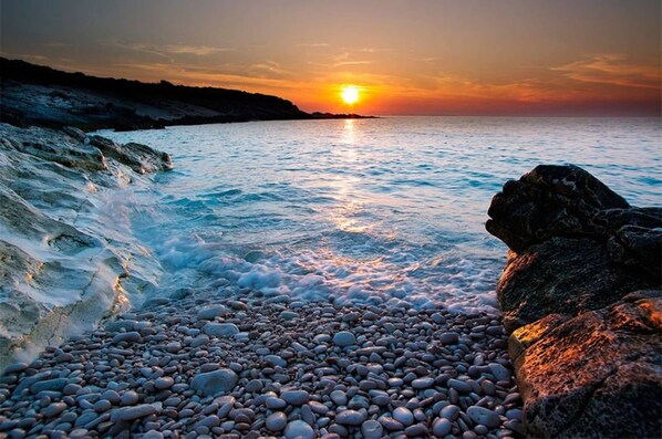 Experience the tranquility of a serene coastal scene with waves gently lapping against the pebbly beach.