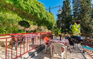 Relax outdoors with a patio featuring a table, chairs, and a grill, surrounded by lush greenery.