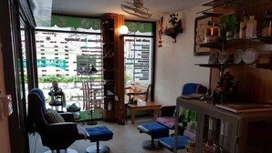 Ein Saloninneres mit Empfangsbereich, Wartebereich mit Stühlen und einer Theke mit verschiedenen Artikeln.