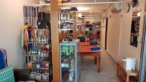 Un espace de vie compact comprenant un coin cuisine, un coin repas et un coin salon avec un canapé et un fauteuil.