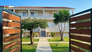 A gated entrance to a building with a stone pathway leading to a door. - Elysian Luxury Studio 4 (Roda, Corfu)