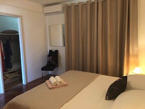 Relax in this inviting room with a comfortable bed, plush chair, and convenient wardrobe.