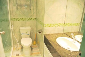 Un baño con inodoro, ducha y lavamanos.