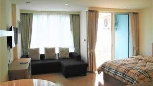 A hotel room with a bed, a sofa, a desk, and a chair. - The Cliff sea & Pool Views Studio Apartment Pratumnak Pattaya (Pattaya)