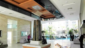 A spacious lobby with a seating area, a reception desk, and a view of an outdoor pool area. - The Cliff sea & Pool Views Studio Apartment Pratumnak Pattaya (Pattaya)