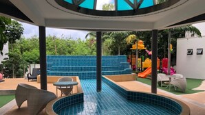 A pool area with a circular hot tub, seating, and a children's play area with slides. - Laguna Beach 1A With Swimming Pool Views Pattaya (Pattaya)