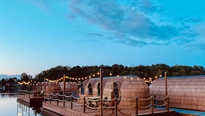 A waterfront area with wooden structures, possibly for dining or events, connected by a wooden deck. - Iglu Camp Templin (Templin)