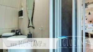 A modern bathroom with a large mirror, a sink, and a shower area. - Iglu Camp Templin (Templin)