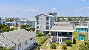 A coastal residential area with multi-story houses, a small dock, and a clear sky.