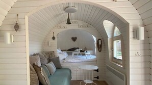 Una habitación acogedora de forma abovedada con una cama, una mesita y un sofá.