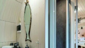 Un baño con un espejo grande, inodoro, lavabo y zona de ducha.
