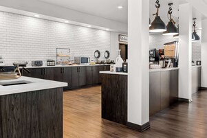 Una cocina moderna con salpicadero de ladrillo blanco, armarios de madera oscura y una isla central.
