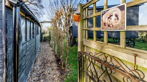 A wooden gate with a sign, a gravel path, and a wooden structure in the background. - 1 bedroom accommodation in Hassocks (Hassocks)