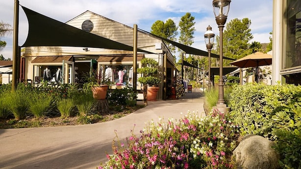 A storefront with a covered walkway, potted plants, and a street lamp. - Christmas Welk San Diego California 2 bedroom Lock Off (San Diego)