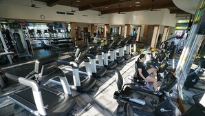 Un gimnasio con cintas de correr, bicicletas estáticas y máquinas de pesas.