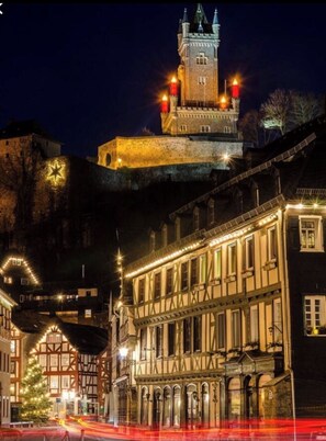 Experience the grandeur of this historic castle, featuring a striking tower and adjacent half-timbered building with a blend of medieval and Renaissance influences.