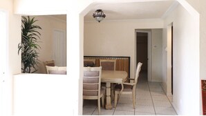 A dining area with a table and chairs, a hanging light fixture, and a door leading to another room. - Family home , canal view, 10 min a way from Naples pier (Naples)