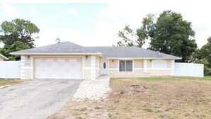 A single-story house with a garage, a front yard, and a driveway. - Family home , canal view, 10 min a way from Naples pier (Naples)