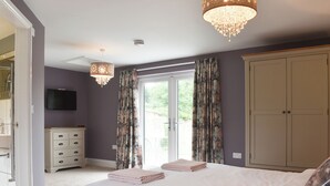 A bedroom with a bed, a dresser, a television, and a wardrobe.