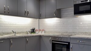 A modern kitchen with grey cabinets, a stainless steel oven, and a microwave. - The Milking Parlour - UK30866 (St Bees, near Whitehaven)
