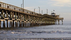 A pier extending into the water with a small structure at the end. - Havens 423 with Pool View! Great Location! (North Myrtle Beach)