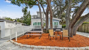 A patio area with outdoor seating and a white railing. - Dunedin Cottage on Pinellas Trail w/ Heated Pool, Walk or Bike to Downtown Dunedin! (Dunedin)