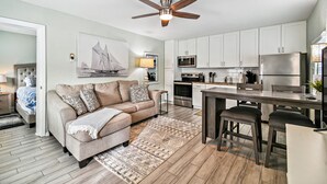 A modern kitchen with white cabinets, stainless steel appliances, and a central island with stools.