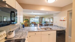 A modern kitchen with a marble countertop, built-in appliances, and a dishwasher.