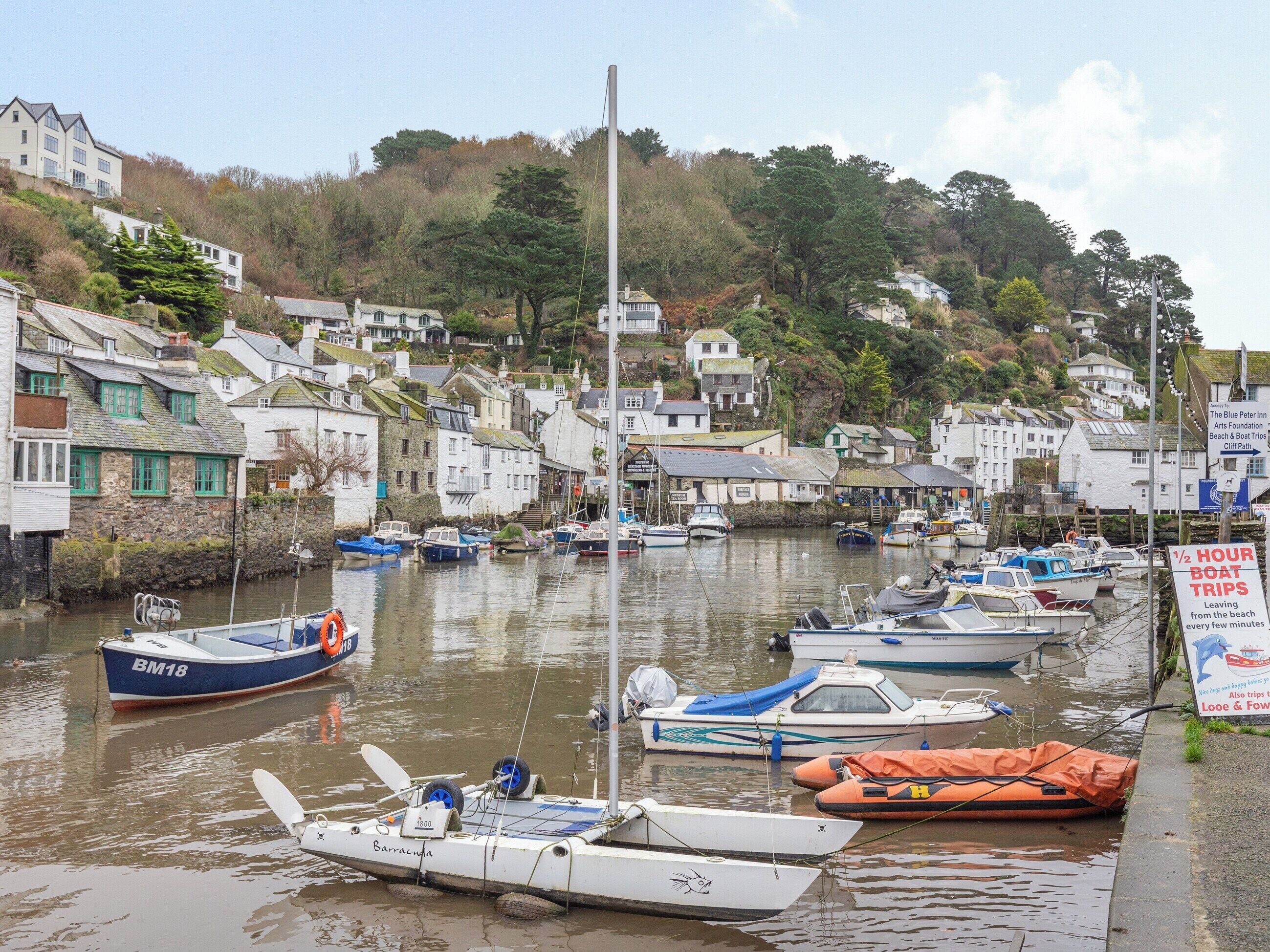 A harbor with boats docked and a sign advertising boat trips.
