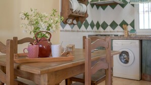 A wooden dining table with a tray holding a teapot, a mug, and a potted plant. - Beautiful Accommodation "Casa Clavel" with Private Pool, Air Conditioning and Terrace (Conil de la Frontera)