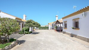 A paved street lined with white buildings, some with small balconies and potted plants. - Beautiful Accommodation "Casa Clavel" with Private Pool, Air Conditioning and Terrace (Conil de la Frontera)