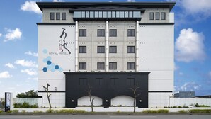 A modern hotel building with a large sign reading "Royal Hotel".