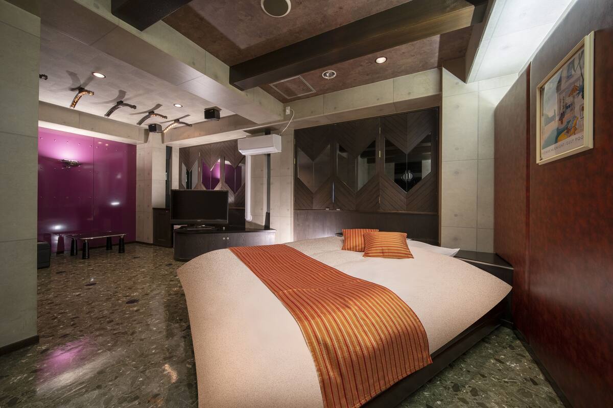 Een moderne hotelkamer met een groot bed, een bureau en een zithoek.