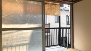 A room with a sliding glass door leading to a balcony. - ZAITO Tokyo Waseda Economy Inn (Tokyo)