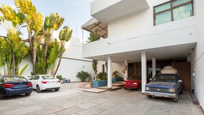 A two-story building with a covered parking area. - Hotel Parador San Jose (Oaxaca)