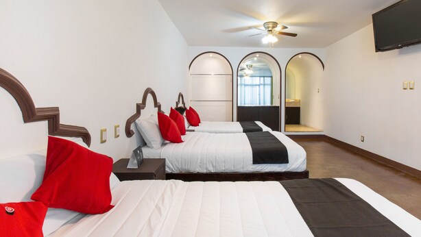 A modern hotel room with two beds, a ceiling fan, and a TV mounted on the wall. - Hotel Parador San Jose (Oaxaca)