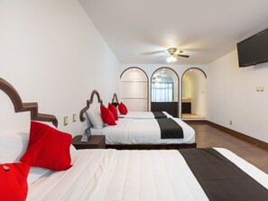 A modern hotel room with two beds, a ceiling fan, and a TV mounted on the wall. - Hotel Parador San Jose (Oaxaca)