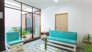 A room with a sofa, two chairs, a coffee table, and a door. - Hotel Parador San Jose (Oaxaca)