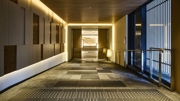 A modern hotel corridor with a checkered floor, recessed lighting, and a view of the lobby area. - The Royal Park Hotel Kyoto Umekoji (Kyoto)