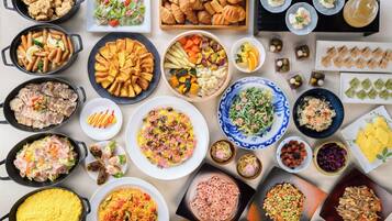 A variety of dishes arranged on a table, including salads, meats, and pastries.