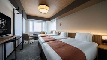A hotel room with a large bed, a desk, a chair, and a television.