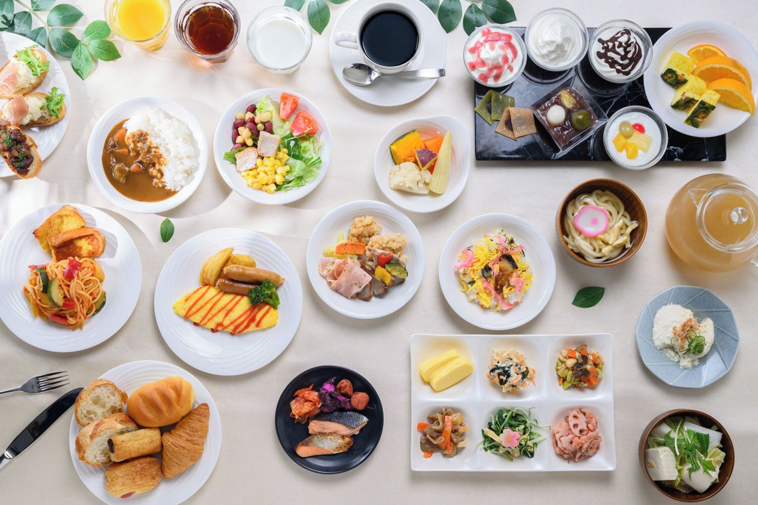 A variety of dishes and beverages on a table, including sushi, pasta, and salads.